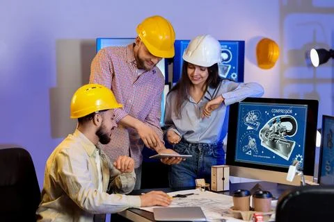 Group of engineers working with tablet computer in office at night 스톡 사진
