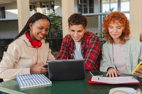 Group of enthusiastic students engaged in collaborative learning while using a Stock Photos