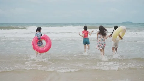 Group of Ethnically Diverse Children Laughing, Running in Sea, Carefree Summer Stock Footage 314061373