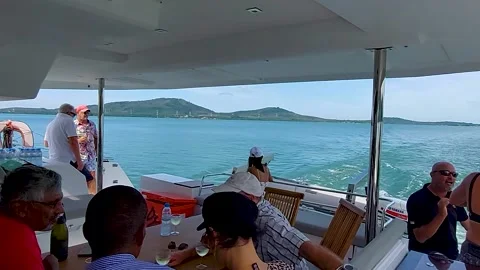A group of European tourists communicate while walking on a sailing catamaran Stock Footage 169169710