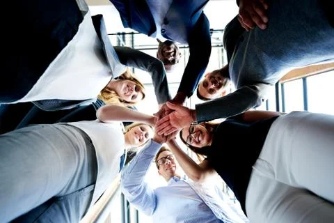 Group of executives looking down hands together Stock Photos