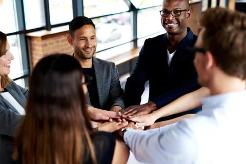 Group of executives standing with hands together Stock Photos