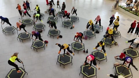 Group Exercise Session on Trampolines in a Modern Indoor Setting Stock Footage 308343706