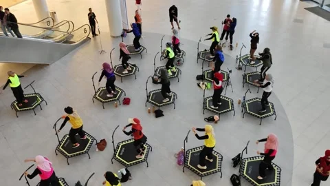 Group Exercise Session on Trampolines in a Modern Indoor Setting Stock Footage 308345133
