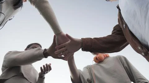 A group of faceless Friends stacking their hands together Stock Photos