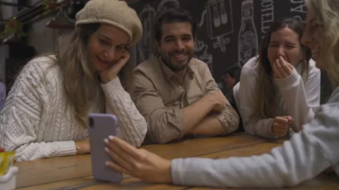 Group facetime a distant lost friend with buddies at the bar Stock Footage 157094338
