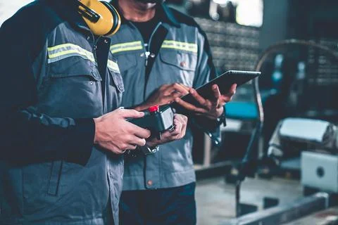 Group of factory job workers using adept machine equipment in a workshop Stock Photos