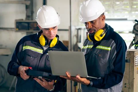 Group of factory job workers using adept machine equipment in a workshop Stock Photos