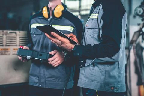 Group of factory job workers using adept machine equipment in a workshop Stock Photos