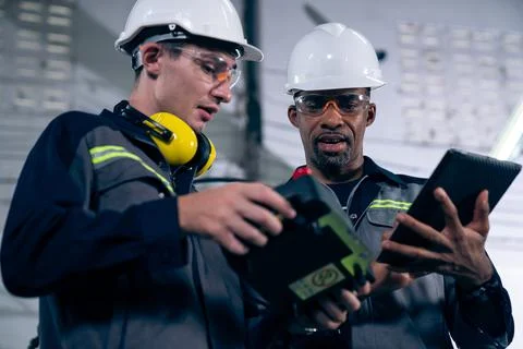 Group of factory job workers using adept machine equipment in a workshop Stock Photos