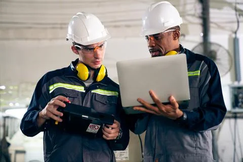 Group of factory job workers using adept machine equipment in a workshop Stock Photos