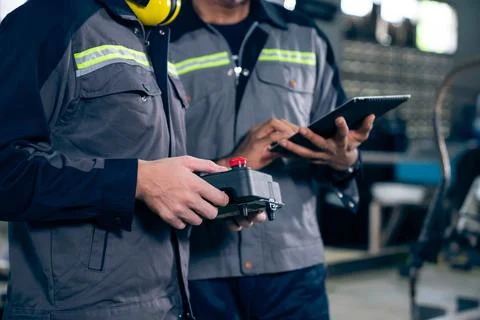 Group of factory job workers using adept machine equipment in a workshop Stock Photos