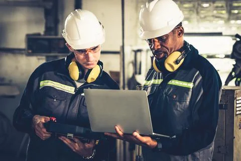 Group of factory job workers using adept machine equipment in a workshop Stock Photos