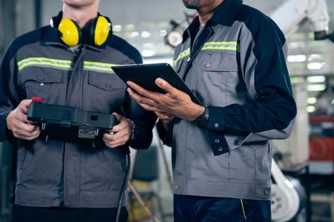 Group of factory job workers using adept machine equipment in a workshop Stock Photos