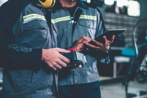 Group of factory job workers using adept machine equipment in a workshop Stock Photos