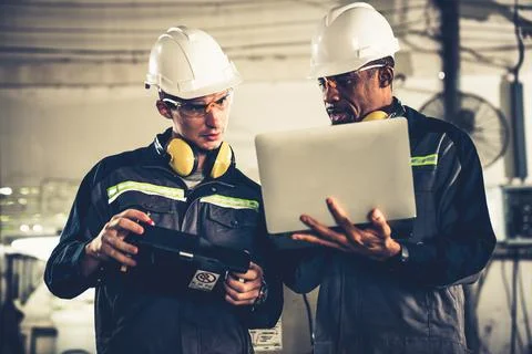 Group of factory job workers using adept machine equipment in a workshop Stock Photos