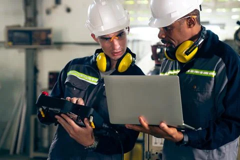 Group of factory job workers using adept machine equipment in a workshop Stock Photos