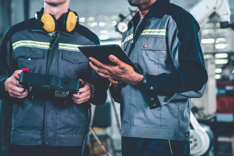 Group of factory job workers using adept machine equipment in a workshop Stock Photos