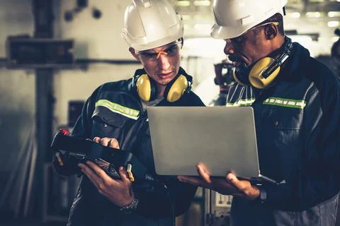 Group of factory job workers using adept machine equipment in a workshop Stock Photos