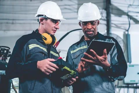Group of factory job workers using adept machine equipment in a workshop Stock Photos