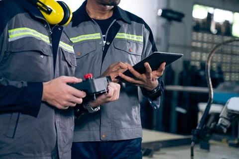 Group of factory job workers using adept machine equipment in a workshop Stock Photos