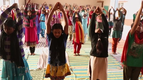 A group of female students practicing Yoga at school auditorium Stock Footage 229784093