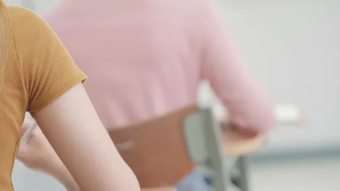 A group of female students sitting in a class and taking exams in a classroom Stock Footage 147956947