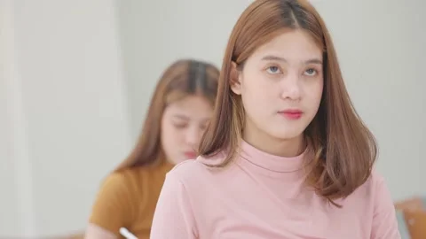 A group of female students sitting in a class and taking exams in a classroom Vidéo 147956958