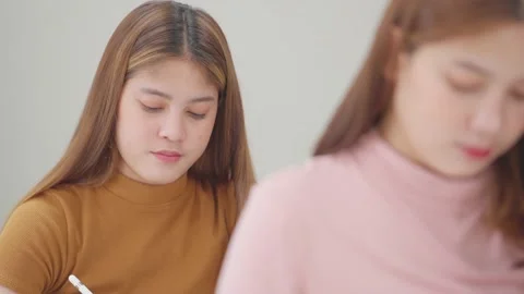 A group of female students sitting in a class and taking exams in a classroom Stock Footage 147956962
