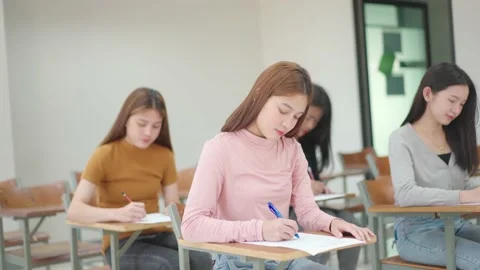 A group of female students sitting in a class and taking exams in a classroom Stock Footage 147956989