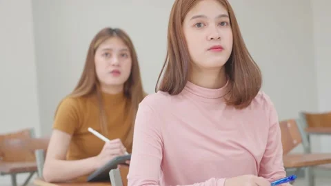 A group of female students sitting in a class and taking exams in a classroom Stock-Footage 147956990