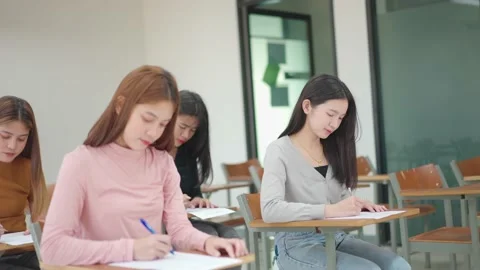 A group of female students sitting in a class and taking exams in a classroom Stock Footage 147957000