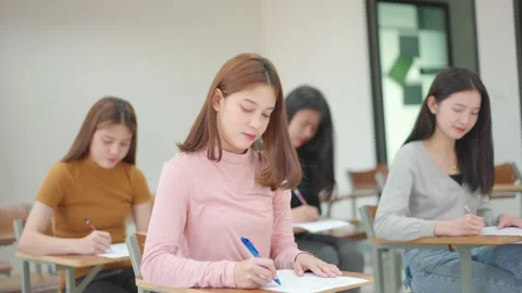A group of female students sitting in a class and taking exams in a classroom Stock Footage 147957028
