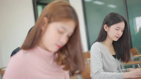 A group of female students sitting in a class and taking exams in a classroom Stock Footage 147957056