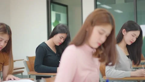 A group of female students sitting in a class and taking exams in a classroom Stock Footage 147957058