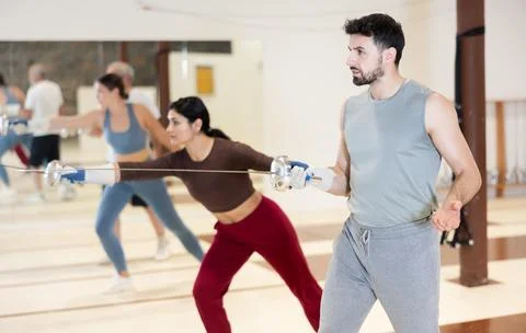Group of fencers practicing sword movements in gym Stock Photos