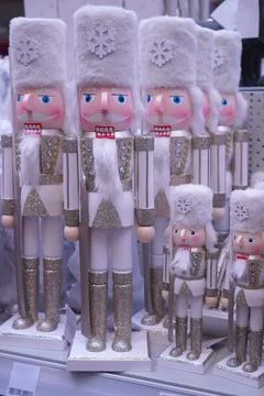 A group of figures of toy nutcrackers in silver suits on the shelves of a h.. Fotos de archivo