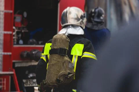 Group of fire men in protective uniform during fire fighting operation in t.. Stock Photos