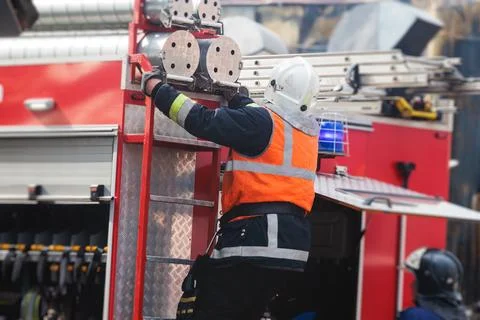 Group of fire men in protective uniform during fire fighting operation in t.. Stock Photos