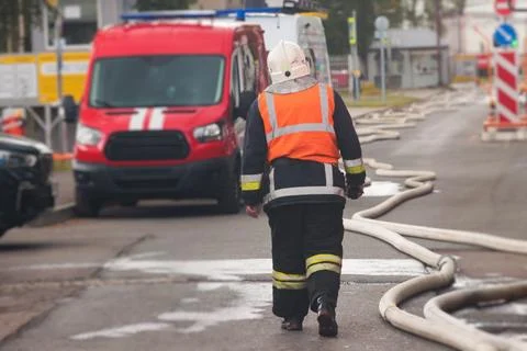 Group of fire men in protective uniform during fire fighting operation in t.. Stock Photos