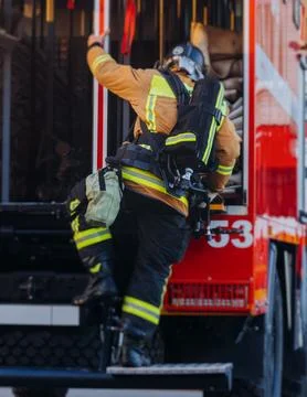 Group of fire men in uniform during fire fighting operation in the city str.. Stock Photos