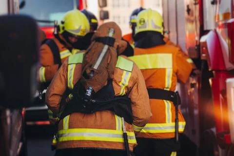 Group of fire men in uniform during fire fighting operation in the city str.. Stock Photos
