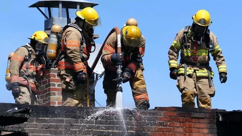 Group of firefighters splashing the bricks of an apartment building Stock Footage 90337403