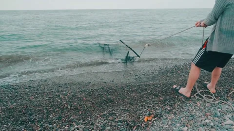 A group of fishermen pulling nets from the sea Stock Footage 196925587