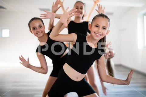 Group of fit happy children exercising ballet and dancing in studio together Stock Photos