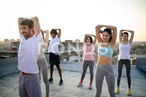 Group of fit healthy friends, people exercising together outdoor on rooftop Stock Photos