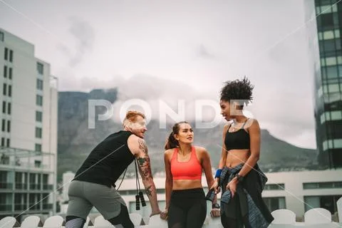 Group of fitness people standing on rooftop after workout Stock Photos