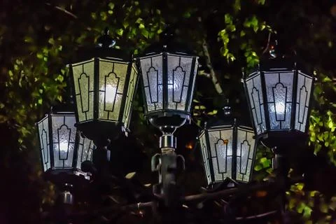 A group of five beautiful street lighting lanterns is against the black sky a Stock Photos