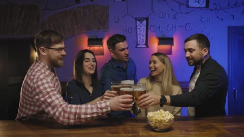 A group of five friends, both men and women, are seen standing around a bar Video stock 286816879