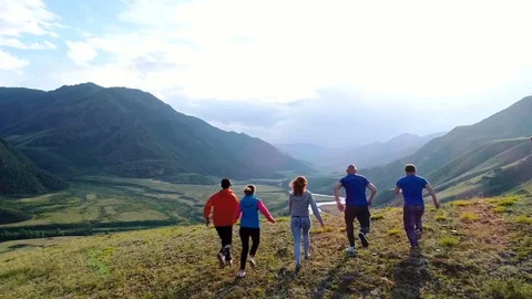 Group of five happy friends jumps at sunset time on background mountains aerial Stock Footage 77866962